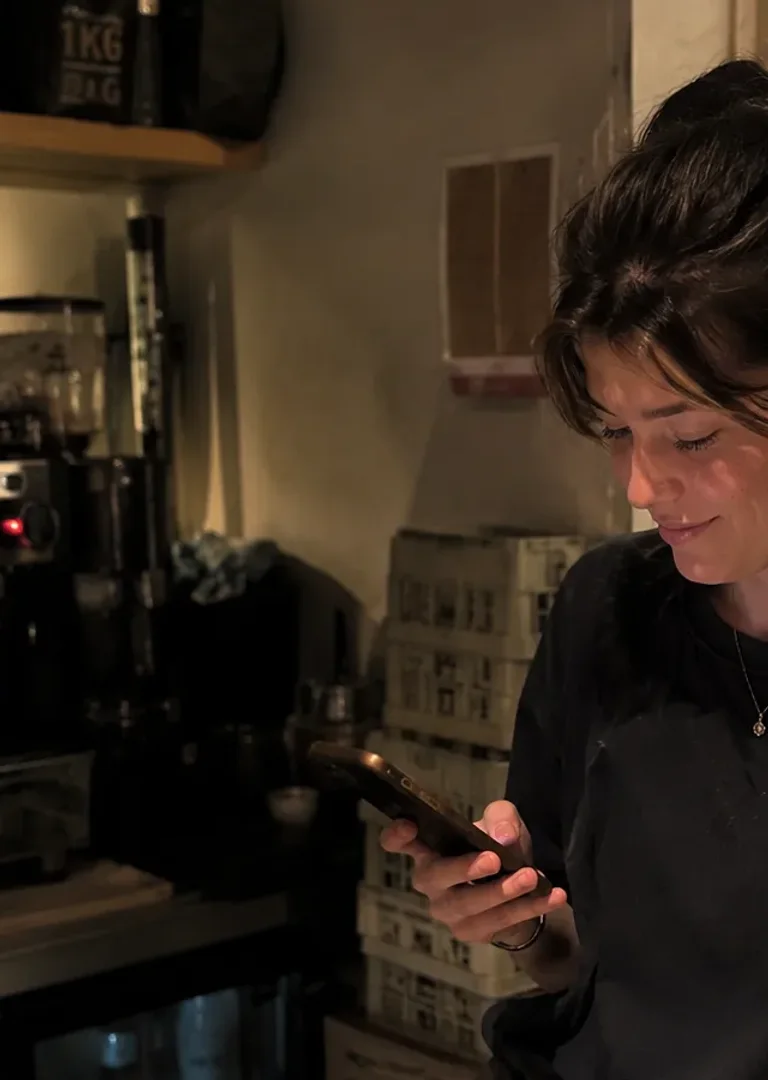 A hospitality worker checking her shifts on her phone before service.